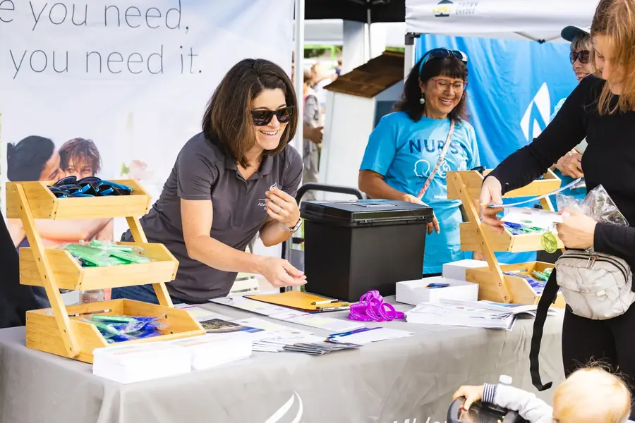 Community health booth serving families at a Portland festival