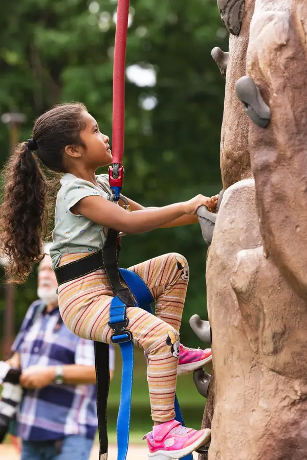 Child climbing the rock wall at a Portland kids event